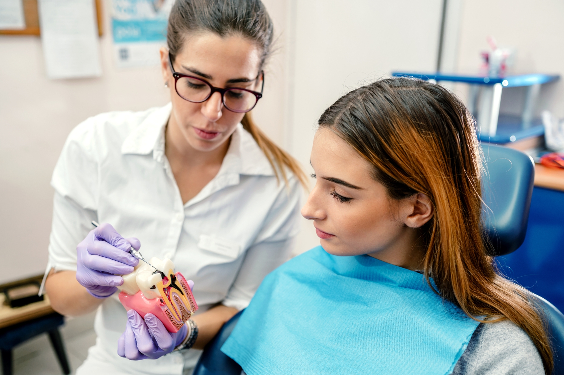 Dental professional explaining gum disease to a patient using a dental model