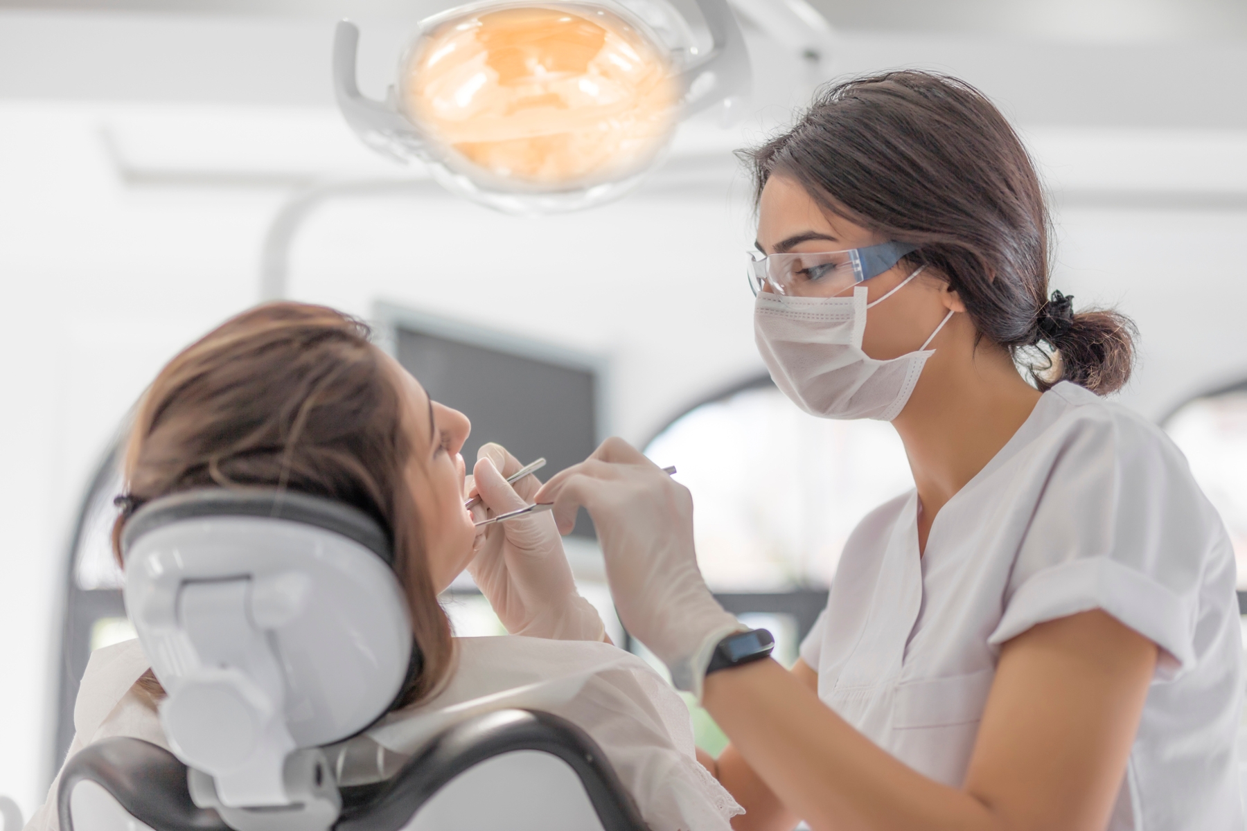 Dentist examining a patient’s tooth during tooth-colored filling treatment