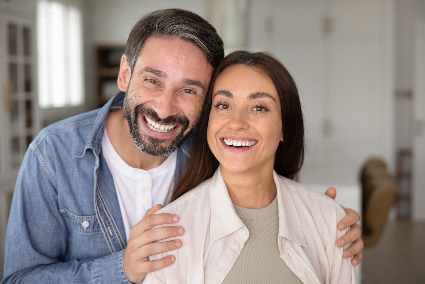 Smiling couple representing restored confidence after dental implant treatment