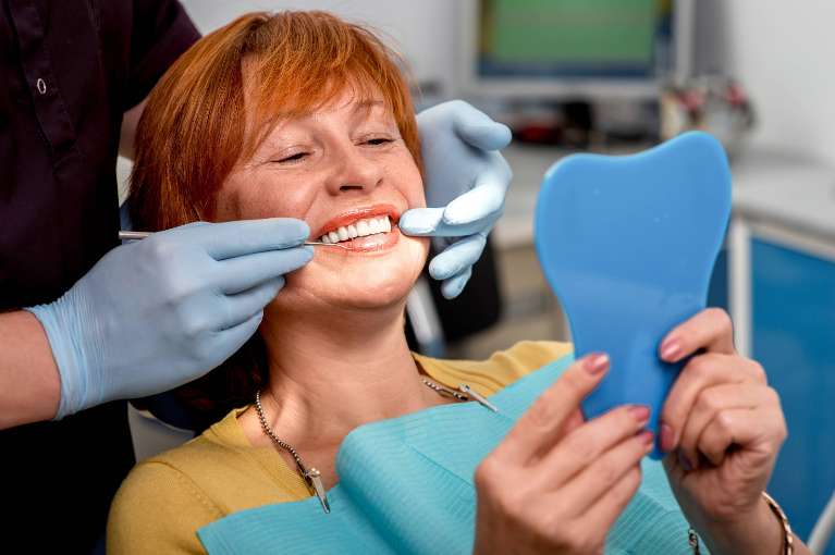 woman getting modern dentures placed in High Point